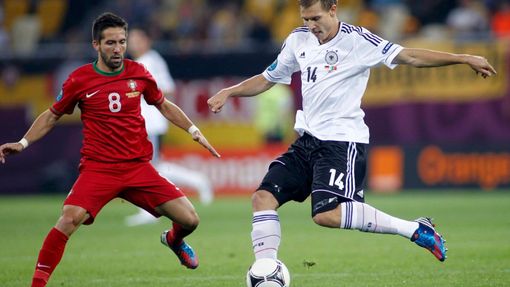 Joao Moutinho se snží bránit Holgera Badstubera během utkání Německa s Portugalskem v základní skupině B na Euru 2012.