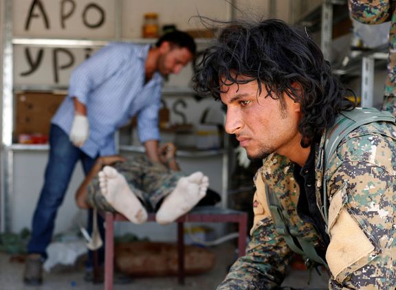 Bojovník Syrských demokratických sil (SDF) čeká v nemocnici v Rakce, kde jeho kamaráda trefil sniper Islámského státu.