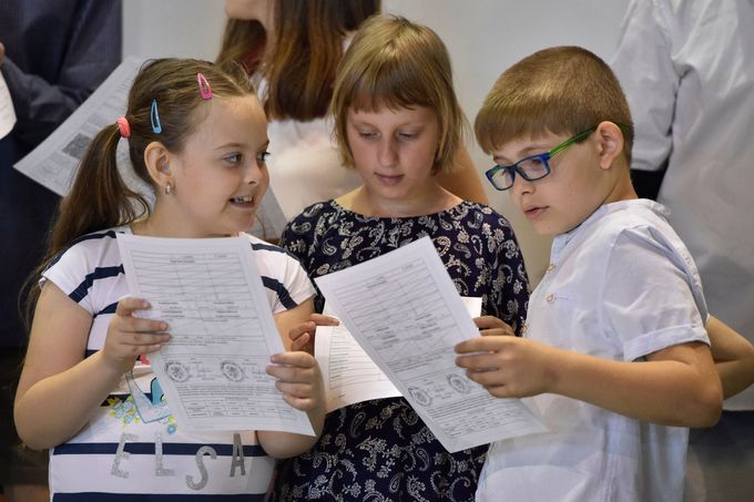 Žáci první třídy si prohlížejí vysvědčení, které jim předal 28. června 2019 na základní škole v Brně-Jundrově ministr školství Robert Plaga