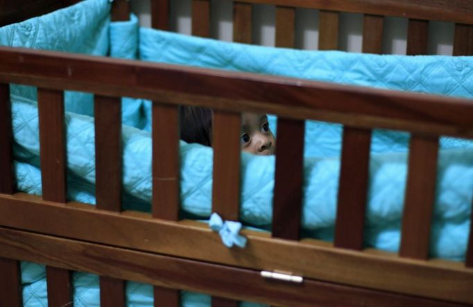 A baby stands in a crib in a bedroom of the San Jose Hospice, in Sacatepequez, 45 km (28 miles) of Guatemala City, November 30, 2012. About 68 HIV-infected children receive free medical care at the hospice, many of them were found abandoned in markets, churches, fire stations, left neglected in hospitals or in some instances, brought in by their families who cannot afford to pay for their medical treatment. World AIDS Day which falls on December 1 is commemorated across the world to raise awareness of the pandemic. REUTERS/Jorge Dan Lopez (GUATEMALA - Tags: ANNIVERSARY HEALTH) Published: Pro. 1, 2012, 2 dop.