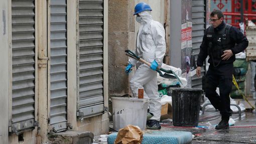 Francouzský policista a forenzní expert vcházejí do domu v Saint-Denis, kde se ukrýval pravděpodobný strůjce teroristických útoků v Paříži z 13. listopadu 2015.