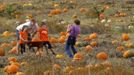 Sara Thomas (R) takes a photograph of her family after they selected their Halloween pumpkins at Mayne's Tree Farm in Buckeystown, Maryland October 27, 2012. Also pictured are (L-R) daughter Olivia, husband Jeff, and son Ryan. Halloween is four days away. REUTERS/Gary Cameron (UNITED STATES - Tags: SOCIETY) Published: Říj. 27, 2012, 8:50 odp.