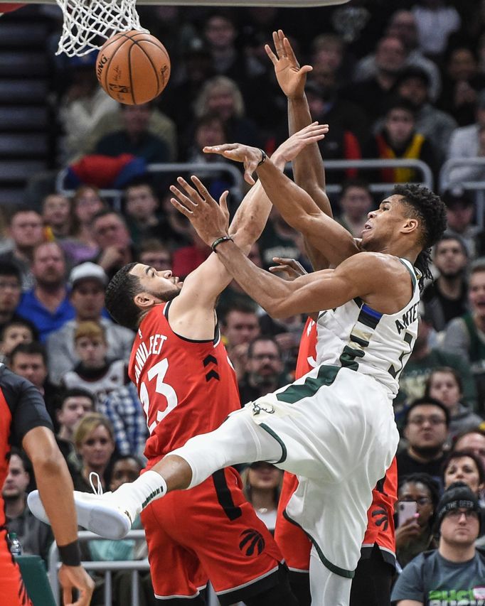 Giannis Antetokounmpo (34) z Milwaukee bojuje o míč s hráčem Toronta Fredem VanVleetem.