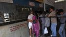 Mahesh Chaturvedi (L), 63, who dresses up like Mahatma Gandhi, stands in a queue at the railway station in New Delhi September 28, 2012. Chaturvedi says that the soul of Gandhi resides in him and he has been sent to continue the work of Father of the Nation. After his self proclaimed transformation in 2002 as Gandhi, Chaturvedi has been travelling extensively and plays up to his startling resemblance to Gandhi at protests and demonstrations. Picture taken September 28, 2012. REUTERS/Mansi Thapliyal (INDIA - Tags: SOCIETY) Published: Lis. 26, 2012, 3:55 dop.