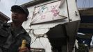 A rescue worker stands in front of damaged houses after a strong 6.6 magnitude earthquake, at Longmen village, Lushan county, Ya'an, Sichuan province April 20, 2013. The earthquake hit a remote, mostly rural and mountainous area of southwestern China's Sichuan province on Saturday, killing at least 102 people and injuring about 2,200 close to where a big quake killed almost 70,000 people in 2008. REUTERS/Stringer (CHINA - Tags: DISASTER) CHINA OUT. NO COMMERCIAL OR EDITORIAL SALES IN CHINA Published: Dub. 20, 2013, 9:18 dop.