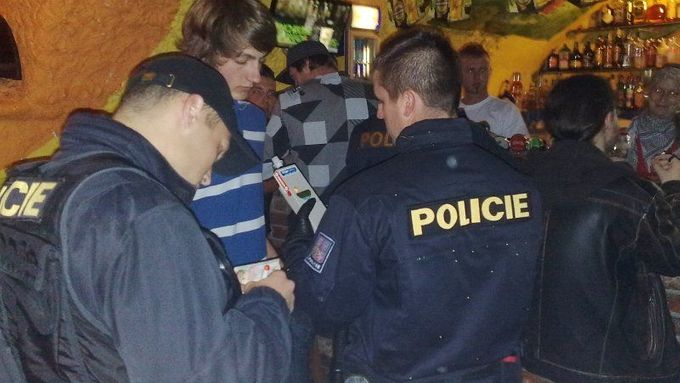 Policisté provádějí dechovou zkoušku u jednoho z nezletilích návštěvníků opavského baru.