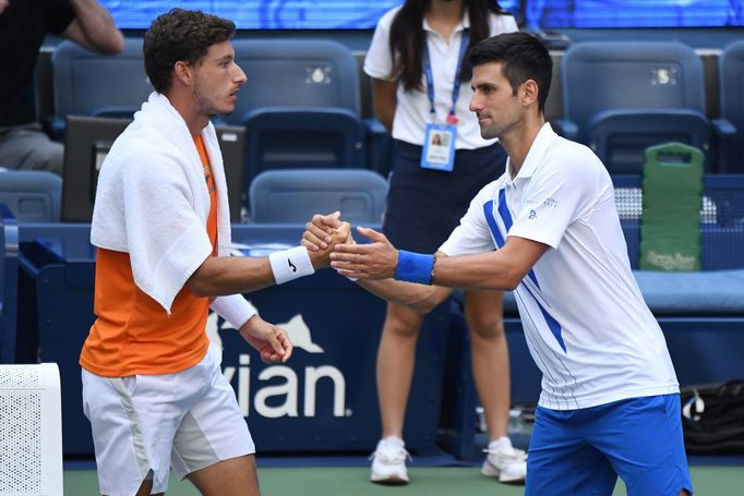 Sep 6, 2020; Flushing Meadows, New York, USA; Novak Djokovic of Serbia shakes hands with Pablo Carreno Busta of Spain after being defaulted for striking a lines person wi