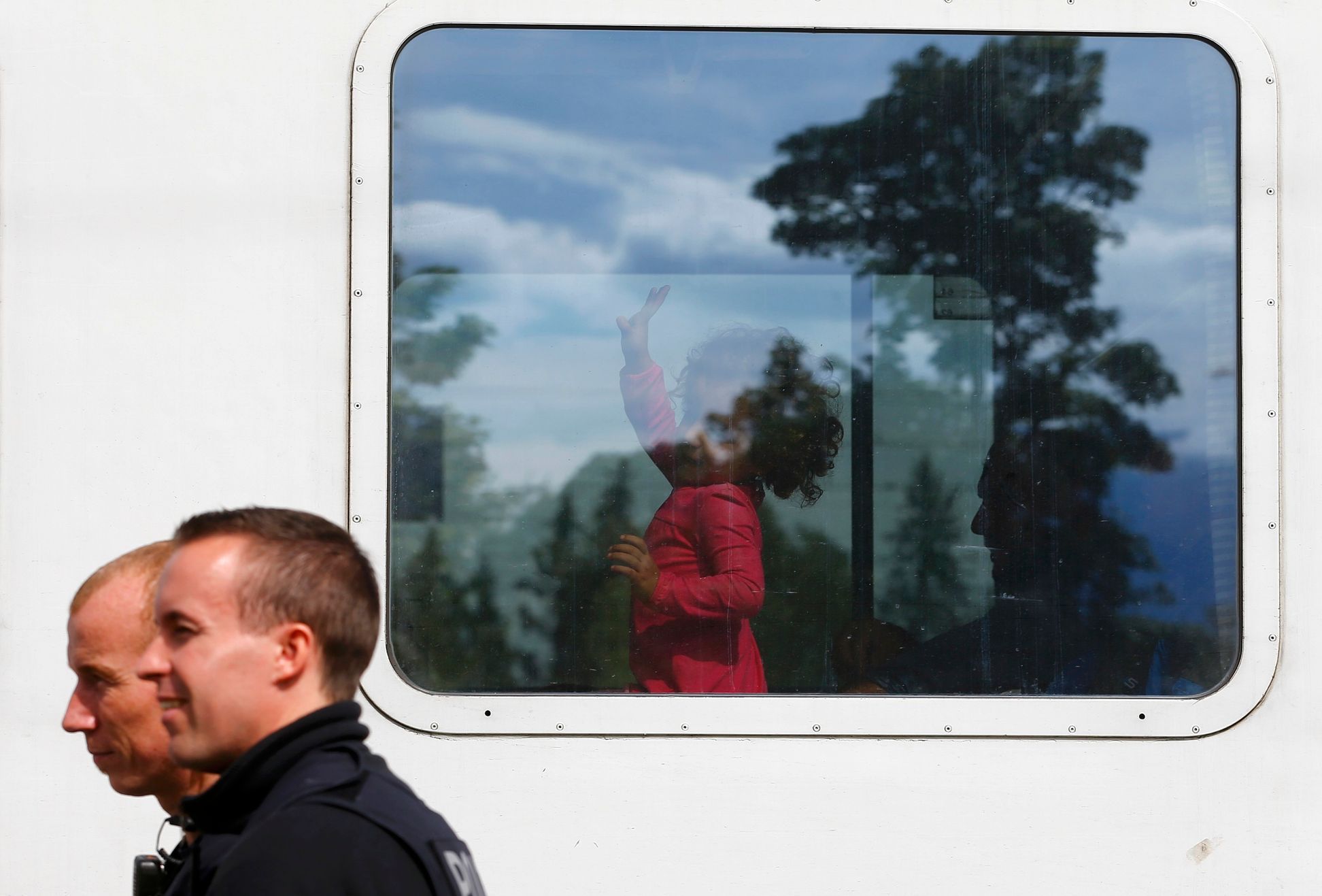 Policisté míjejí vlak s migranty v německém Freilassingu nedaleko hranic s Rakouskem.