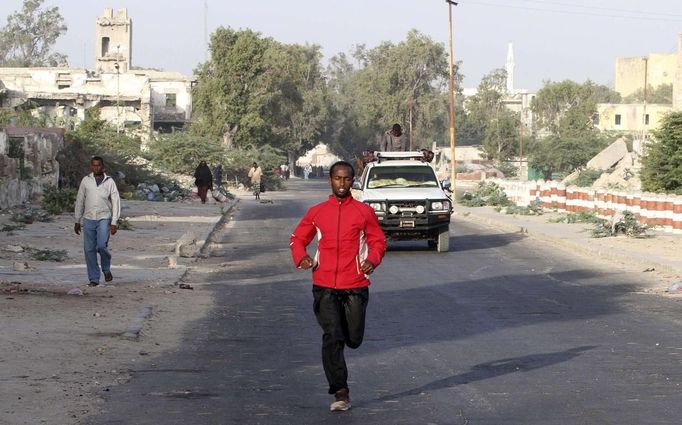 Somali athlete Mohamed Hassan Mohamed runs along a street as he trains during preparations for the 2012 London Olympic Games in Somalia's capital Mogadishu in this March 14, 2012 file photo. Training in a bullet-riddled stadium where the remains of a rocket propelled grenade lies discarded on the track's edge counts as progress for Somali Olympic hopeful Mohamed Hassan Mohamed. A year ago, Mogadishu's Konis stadium was a base for Islamist militants and a work out meant at times running through the streets, dodging gun-fire and mortar shells in one of the world's most dangerous cities. Picture taken March 14, 2012. To match OLY-SOMALIA-HOPES/ REUTERS/Feisal Omar/Files (SOMALIA - Tags: SPORT ATHLETICS SOCIETY OLYMPICS) Published: Čer. 11, 2012, 7:12 dop.