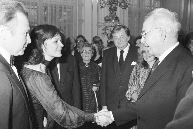 Luděk Munzar a Jana Hlaváčová se vítají s prezidentem ČSSR Gustávem Husákem na recepci ke státnímu svátku ČSSR v místnostech Pražského hradu