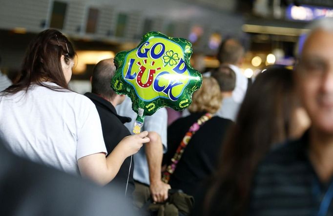 A woman with a balloon reading "good luck" queues at a Lufthansa airline check-in desk at the Fraport airport in Frankfurt, August 31, 2012. Lufthansa cancelled 64 flights at its main hub Frankfurt on Friday as cabin crew began the first of a series of strikes over pay and cost cuts in a busy holiday season. The eight-hour industrial action, following the breakdown of 13 months of negotiations between Germany's largest airline and trade union UFO, is due to end at 1100 GMT on Friday. REUTERS/Kai Pfaffenbach (GERMANY - Tags: BUSINESS EMPLOYMENT CIVIL UNREST TRANSPORT) Published: Srp. 31, 2012, 9:28 dop.