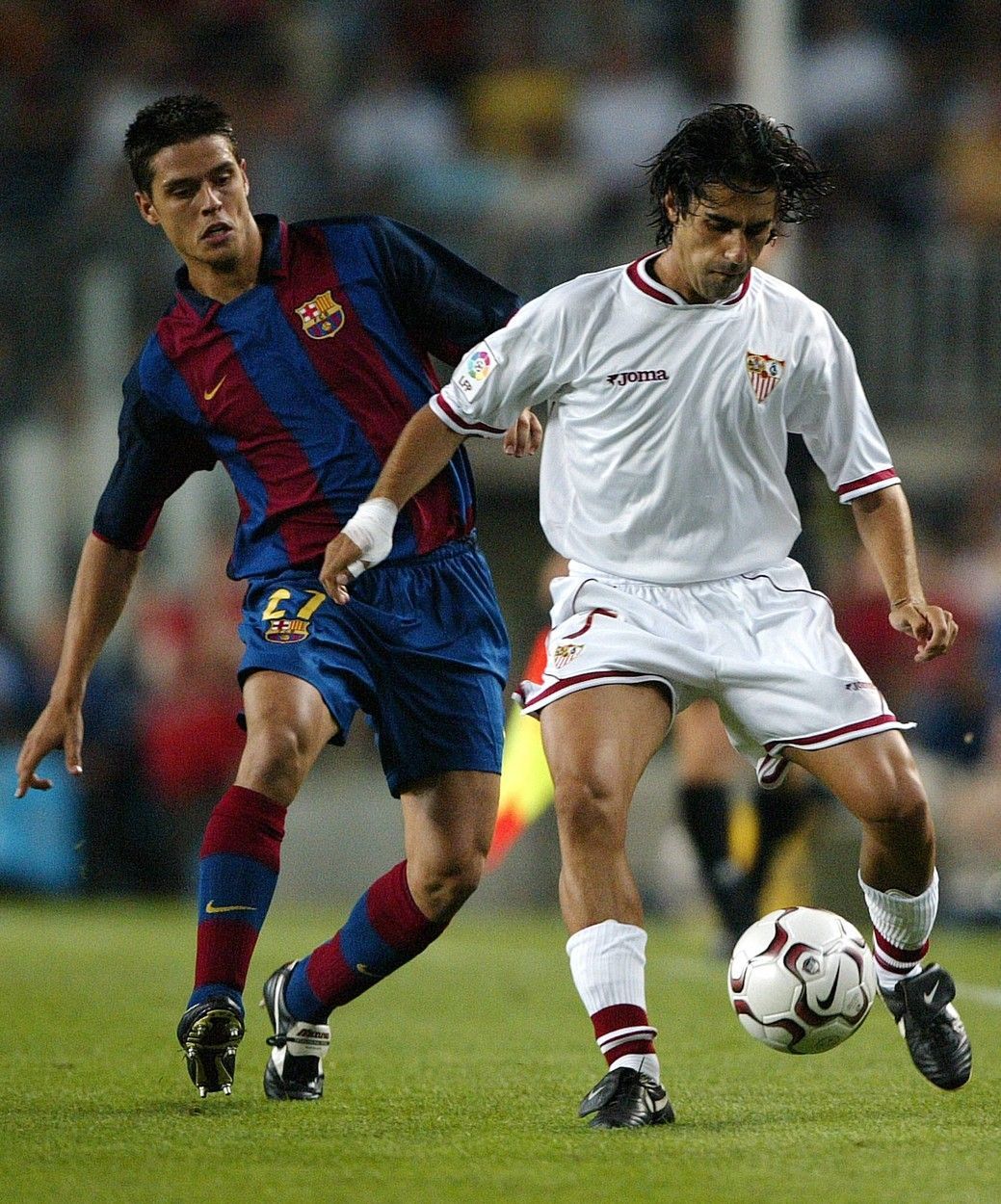 FC Barcelona's Oscar Lopez (L) fights for the ball with Sevilla's Gallardo (R) during their Spanish League soccer match at the Camp Nou stadium in Barcelona, 02 September 2003