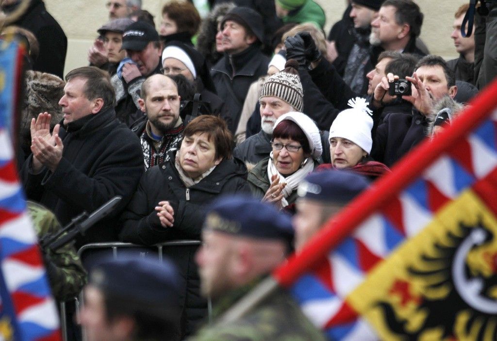 Lidé se dívají nakev s ostatky na lafetě historické houfnice