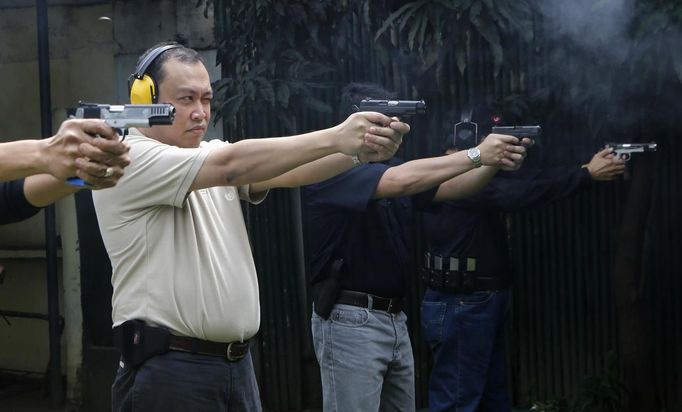 Jaime "Jimmy" Santiago (L - not in picture), a lower court judge in Manila, and fellow court judges fires their service pistol during shooting practice at a police firing range in Manila March 6, 2013. Santiago, a former police officer who headed a special weapons and tactics (SWAT) unit, favours arming Filipino judges to protect themselves from disgruntled litigants who can't accept decisions and criminal syndicates whose members were sent to jail. There had been cases of shootings inside courtrooms. In photo from L-R: Judge court Jaime Santiago, Judge court Emilio Legazpi III, Judge coourt Jose Lorenzo Dela Rosa and Judge court Armando Yanga. Picture taken March 6, 2013. REUTERS/Romeo Ranoco (PHILIPPINES - Tags: POLITICS CRIME LAW) Published: Dub. 4, 2013, 11:16 dop.