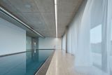 Uvnitř luxusní vily, která má okolo 1000 metrů čtverečních užitné plochy, je bazén se stropem z pohledového betonu.