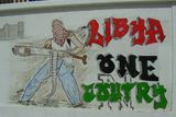 Libya One Coutry. Autorovi vypadlo jedno n, nicméně graffiti má sdělit, že povstalci odmítají rozdělení Libye na západní a východní. Neusilují o vlastní stát, chtějí jednotnou Libyi s hlavním městem Tripolisem.