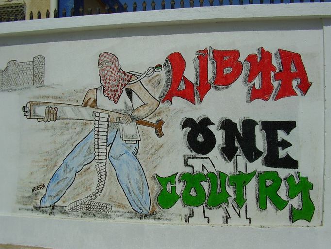 Libya One County. Autorovi vypadlo jedno r, nicméně graffiti má sdělit, že povstalci odmítají rozdělení Libye na západní a východní. Neusilují o vlastní stát, chtějí jednotnou Libyi s hlavním městem Tripolisem.