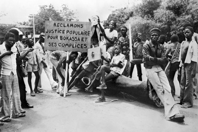 Demonstranti u zničené sochy svrženého diktátora Středoafrické republiky Jeana-Bédela Bokassiho. Snímek pořízený v Bangui v roce 1979.