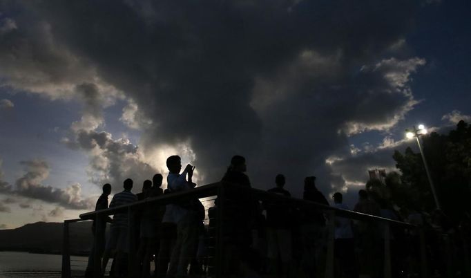 Tourists look to the sky as clouds obscure a full solar eclipse in the northern Australian city of Cairns November 14, 2012. REUTERS/Tim Wimborne (AUSTRALIA - Tags: SOCIETY ENVIRONMENT) Published: Lis. 13, 2012, 10:02 odp.