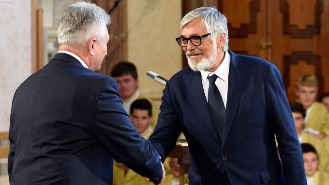 Herec Jiří Bartoška přebírá z rukou šéfa Senátu Milana Štěcha stříbrnou pamětní medaili.