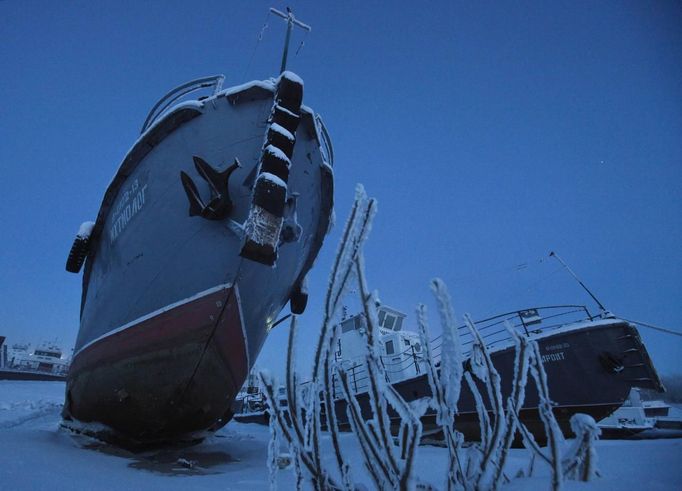 Ships are moored on the banks of a river for the winter outside Yakutsk in the Republic of Sakha, northeast Russia, January 18, 2013. The coldest temperatures in the northern hemisphere have been recorded in Sakha, the location of the Oymyakon valley, where according to the United Kingdom Met Office a temperature of -67.8 degrees Celsius (-90 degrees Fahrenheit) was registered in 1933 - the coldest on record in the northern hemisphere since the beginning of the 20th century. Yet despite the harsh climate, people live in the valley, and the area is equipped with schools, a post office, a bank, and even an airport runway (albeit open only in the summer). Picture taken January 18, 2013. REUTERS/Maxim Shemetov (RUSSIA - Tags: SOCIETY MARITIME TRANSPORT ENVIRONMENT) ATTENTION EDITORS: PICTURE 20 OF 27 FOR PACKAGE 'THE POLE OF COLD' SEARCH 'MAXIM COLD' FOR ALL IMAGES Published: Úno. 18, 2013, 11:26 dop.