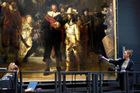 Amsterdam, Nizozemsko: restaurátorka umění ukazuje detail psa na restaurovaném obraze Rembrandtovi Noční hlídky v Rijksmuseum.
