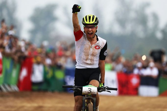 Švýcar Nino Schurter projíždí jako vítěz cílem olympijského závodu horských kol.