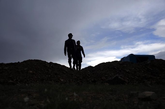 Members of the Mongolian neo-Nazi group Tsagaan Khass walk through a quarry, where they questioned a worker, southwest of Ulan Bator June 23, 2013. The group has rebranded itself as an environmentalist organisation fighting pollution by foreign-owned mines, seeking legitimacy as it sends Swastika-wearing members to check mining permits. Over the past years, ultra-nationalist groups have expanded in the country and among those garnering attention is Tsagaan Khass, which has recently shifted its focus from activities such as attacks on women it accuses of consorting with foreign men to environmental issues, with the stated goal of protecting Mongolia from foreign mining interests. This ultra-nationalist group was founded in the 1990s and currently has 100-plus members. Picture taken June 23, 2013. REUTERS/Carlos Barria (MONGOLIA - Tags: POLITICS ENVIRONMENT BUSINESS SOCIETY EMPLOYMENT) ATTENTION EDITORS: PICTURE 25 OF 25 FOR PACKAGE 'MONGOLIA'S ENVIRONMENTAL NEO-NAZIS'. TO FIND ALL IMAGES SEARCH 'TSAGAAN KHASS' Published: Čec. 2, 2013, 9:59 dop.