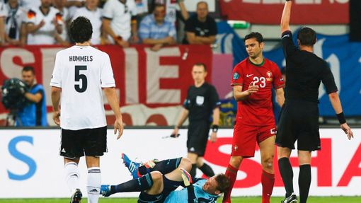 Rozhodčí Stephane Lannoy dává žlutou kartu Helderu Postigovi za faul na Manuela Neuera během utkání Německa s Portugalskem v základní skupině B na Euru 2012.