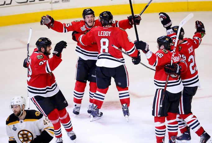 Chicago Blackhawks' Andrew Shaw (65) celebrates with teammates after scoring the game-winning goal against the Boston Bruins during triple overtime in Game 1 of their NHL