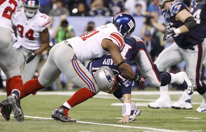 Justin Tuck zastavuje Toma Bradyho