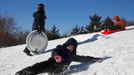 A child slips from his toboggan while kids ride down a hill their toboggans in Jersey City, New Jersey, February 9, 2013. A blizzard packing hurricane-force winds pummelled the northeastern United States on Saturday, killing at least one person, leaving about 600,000 customers without power and disrupting thousands of flights. REUTERS/Eduardo Munoz (UNITED STATES - Tags: ENVIRONMENT DISASTER) Published: Úno. 10, 2013, 12:09 dop.