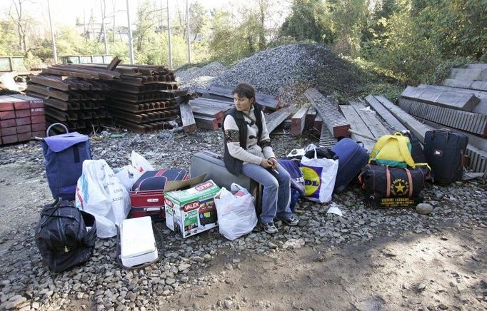 A Romanian woman sits on boxes of belongings after Italian police closed an illegal camp, where a suspected killer lived, in the Tor Di Quinto area of Rome November 2, 2007. Italy's centre-left government, long accused by critics of being soft on immigration, has pushed through a decree allowing police to expel European Union citizens believed to be a danger to society. Italian Prime Minister Romano Prodi rammed through the measure by decree at an emergency cabinet meeting late on Wednesday after police arrested a Romanian man, who lived at the illegal camp, for an attack on an Italian naval officer's wife. She later died in hospital. REUTERS/Max Rossi (ITALY)