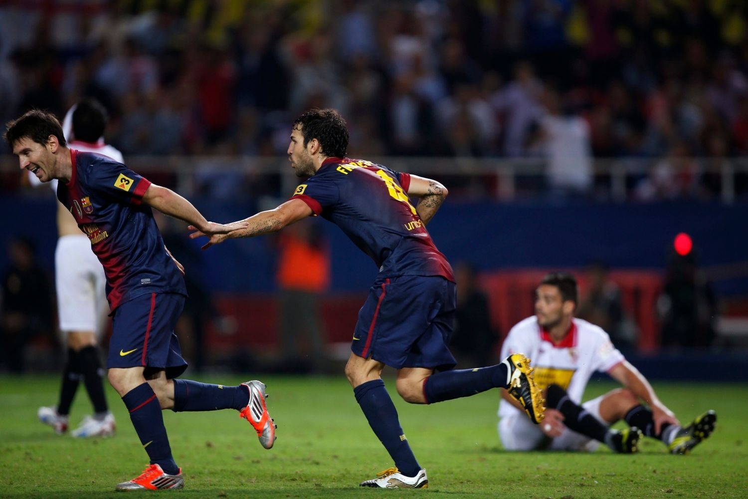 Fotbalisté Barcelony Lionel Messi (vlevo) a Cesc Fabregas slaví gól v utkání španělské La Ligy 2012/13 se Sevillou.