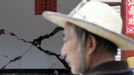 Cracks are seen on a wall as a villager stands in front of a damaged house on the second day after an earthquake hit Longmen township of Lushan county, Sichuan province April 21, 2013. Rescuers struggled to reach a remote corner of southwestern China on Sunday as the toll of the dead and missing from the country's worst earthquake in three years climbed to 203 with more than 11,000 injured. The 6.6 magnitude quake struck in Lushan county, near the city of Ya'an in the southwestern province of Sichuan, close to where a devastating 7.9 temblor hit in May 2008 killing some 70,000. REUTERS/Jason Lee (CHINA - Tags: DISASTER ENVIRONMENT) Published: Dub. 21, 2013, 10:37 dop.