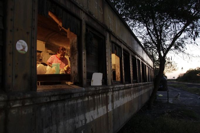 Maria Guadalupe prepares food inside a train carriage she calls home in Cadereyta on the outskirts of Monterrey August 8, 2012. Maria Guadalupe, her eight other family members and their pets have been living in the abandoned carriage next to a train track for the last 15 years. Maria Guadalupe and her husband moved from Tamaulipas to Cadereyta after one of their sons was killed on the street by a stray bullet. The family moved into the carriage, which was empty after having been occupied by a vagabond, after living for the first five years in a rented room after arriving in Cadereyta. Picture taken August 8, 2012 REUTERS/Daniel Becerril (MEXICO - Tags: SOCIETY) Published: Srp. 11, 2012, 1:51 dop.