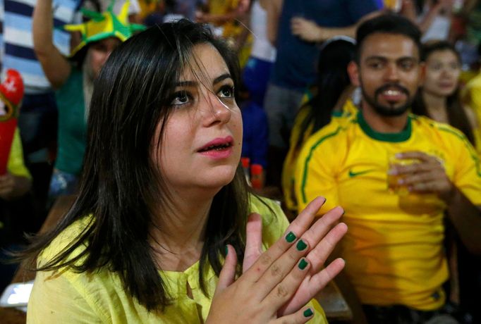 A fan reacts in a cafe in the town of Itu as she watches the 2014 World Cup opening game between Brazil with Croatia June 12, 2014. REUTERS/Maxim Shemetov (BRAZIL - Tags: