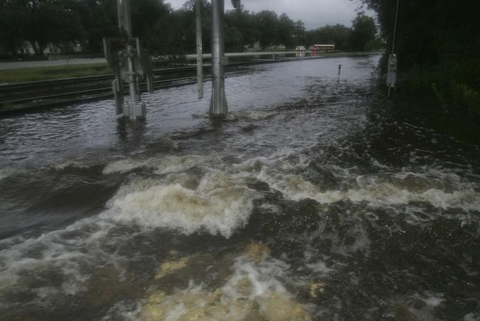 Flood waters rush over a train crossing in Live Oak, Florida, June 26, 2012. Tropical Storm Debby weakened to a tropical depression after it drifted ashore on Florida's Gulf Coast on Tuesday, even as it dumped more rain on flooded areas and sent thousands of people fleeing from rising rivers. Picture taken July 26. REUTERS/Phil Sears (UNITED STATES - Tags: DISASTER ENVIRONMENT) Published: Čer. 27, 2012, 1:42 odp.