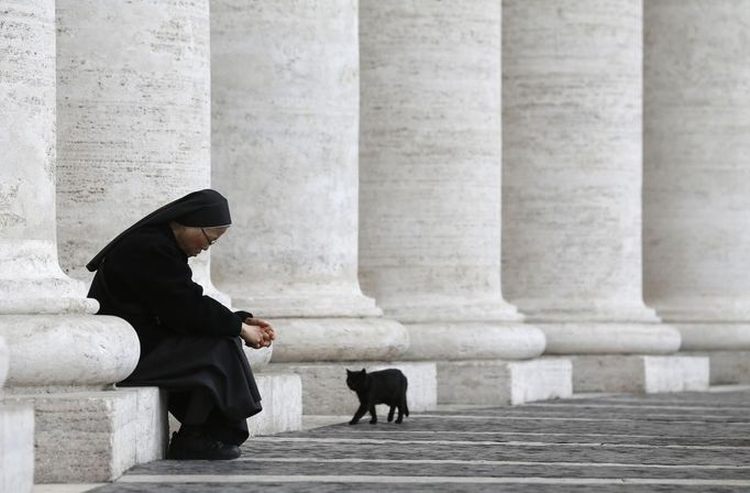 A nun sits at a colonnade in St Peter's Square at the Vatican March 11, 2013. Roman Catholic Cardinals will begin their conclave inside the Vatican's Sistine Chapel on Tuesday to elect a new pope. REUTERS/Christian Hartmann (VATICAN - Tags: RELIGION) Published: Bře. 11, 2013, 11:02 dop.