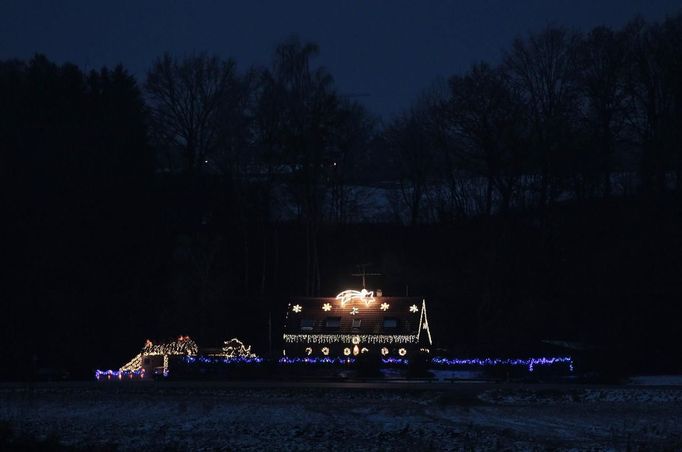 A house decorated with Christmas lights and figurines is lit up in Freising, about 30 km (18.6 miles) north of Munich December 1, 2012. Each year, several home owners set up fairy lights for the year-end holidays. For this particular home, Ulla and Hilmar Haubrich used more than 20,000 lights and 300 empty gift boxes. Picture taken December 1, 2012. REUTERS/Michaela Rehle (GERMANY - Tags: SOCIETY ANNIVERSARY) Published: Pro. 2, 2012, 11:59 dop.