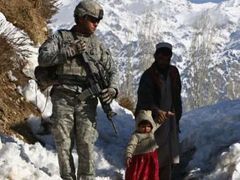 Afghánec s malou dcerkou prochází kolem hlídkujícího amerického vojáka v provincii Paktíja na jihovýchodě země.