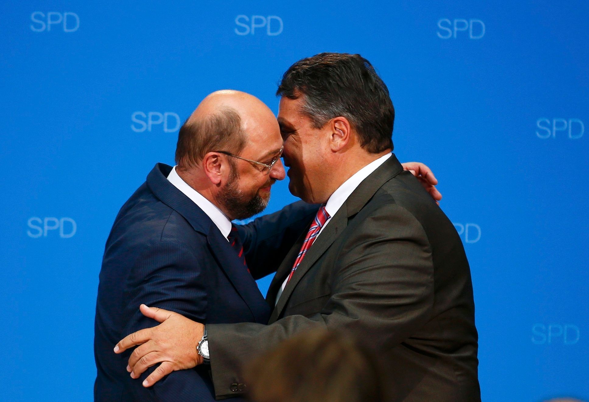 Schulz, candidate for European Commission president of Germany's Social Democratic Party (SPD), embraces SPD chairman Gabriel upon first exit polls in SPD headquarters in Berlin