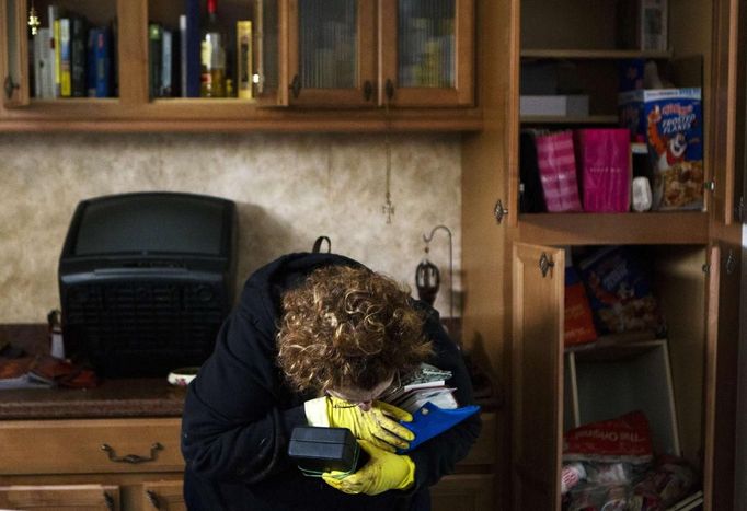 A woman weeps as she is overwhelmed by emotion after finding her family photographs inside of her heavily damaged home in the New Dorp Beach neighborhood of the Staten Island borough of New York, November 1, 2012. Deaths in the United States and Canada from Sandy, the massive storm that hit the U.S. East Coast this week, rose to at least 95 on Thursday after the number of victims reported by authorities in New York City jumped and deaths in New Jersey and elsewhere also rose. REUTERS/Lucas Jackson (UNITED STATES - Tags: ENVIRONMENT DISASTER) Published: Lis. 1, 2012, 10:20 odp.