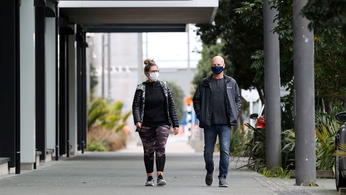 Lidé se prochází během lockdownu v novozélandském Aucklandu. Nošení roušek venku není povinné.