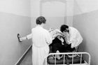Dobový text: "Večer na záchytné stanici U Apolináře v Praze, 1. června 1973. Někdy je zachycený nebezpečný sobě i svému okolí natolik, že musí být na záchytné stanici izolován v místnosti a připoután na lůžko. Když se podaří personálu záchytné stanice pacienta spoutat, sestra mu dá pro uklidnění injekci."