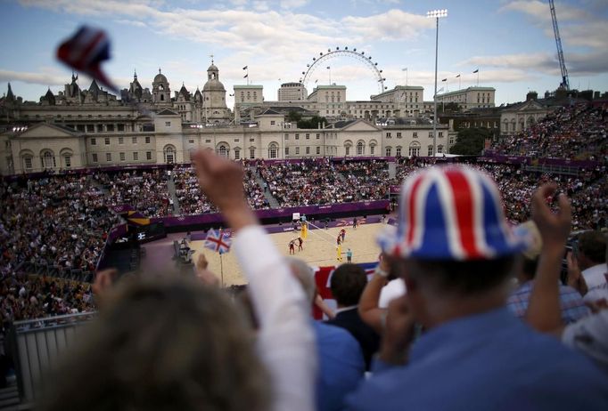 Supporters of Britain's John Garcia-Thompson and Steve Grotowski cheer during their men's preliminary round beach volleyball match against Norway's Tarjei Viken Skarlund and Tarjei Viken Skarlund at Horse Guards Parade during the London 2012 Olympic Games August 1, 2012. REUTERS/Marcelo del Pozo (BRITAIN - Tags: SPORT VOLLEYBALL OLYMPICS) Published: Srp. 1, 2012, 5:42 odp.