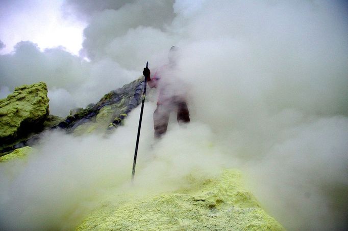 An Indonesian sulphur miner collects sulphur from the crater atop the Ijen volcano in Banyuwangi, on East Java, on December 15, 2009. An active vent at the Ijen volcano 2,300 metres above sea level supports a sulphur mining operation where the collected sulphur is carried by hand in wicker baskets from the crater. The Indonesian archipelago sits on the the Pacific "Ring of Fire," where continental plates collide, and is home to about 130 active volcanoes.