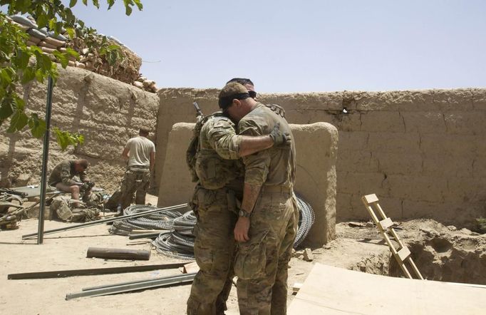 U.S. Army soldiers react after Sgt. Matt Krumwiede was wounded by an improvised explosive device (IED) in southern Afghanistan June 12, 2012. On June 12, 2012, Krumwiede was on patrol in Afghanistan when he stepped on an IED, which tore away both his legs, damaged his left arm, and ripped open his abdominal cavity. The 22-year-old has since undergone around 40 surgeries and is learning to walk with prosthetic legs. He is keen to re-join the infantry as soon as his injuries allow. U.S. troops have been in Afghanistan since 2001. Thousands of Afghan elders gathered in Kabul on November 21, 2013 at a Loya Jirga, or grand council, to debate a crucial security pact with the United States, a day after Kabul and Washington reached a draft agreement laying out the terms under which U.S. troops may stay beyond 2014. Picture taken June 12, 2012.