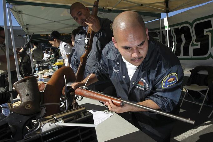 A Los Angeles County Sheriff's volunteer catalogues guns being traded in at the "Gifts for Guns" gun buyback in Compton, California, January 21, 2013. People can trade in their guns anonymously and with no questions asked in exchange for $200 gift cards for assault weapons, $100 gift cards for shotguns, handguns and rifles, and $50 for non-operational firearms. U.S. President Barack Obama is pushing to address controversial issues surrounding gun violence and regulation as he begins his second term in office. REUTERS/David McNew (UNITED STATES - Tags: POLITICS SOCIETY) Published: Led. 21, 2013, 10:33 odp.