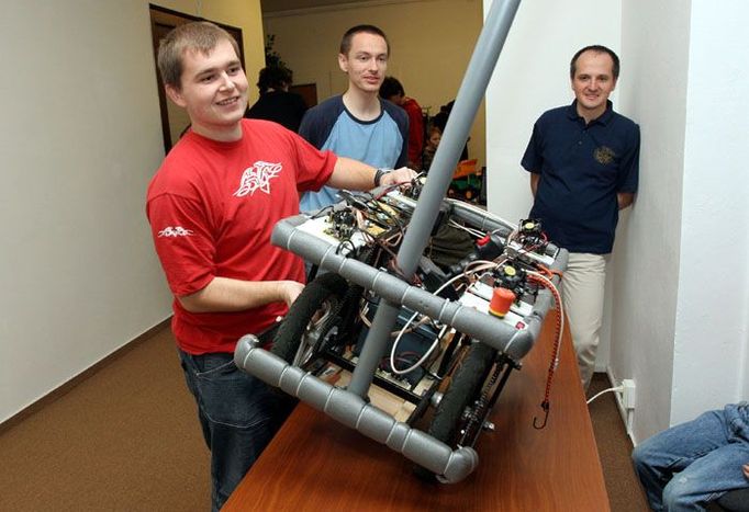 I tento robot závodil ve Stromovce na Robo Tour 2006. Jeho váha je asi třicet pět kilo. "Podívejte se, každý robot má mít velký červený vypínač," ukazuje jeho konstruktér Kamil Řezáč (vlevo) tlačítko vpravo nahoře.